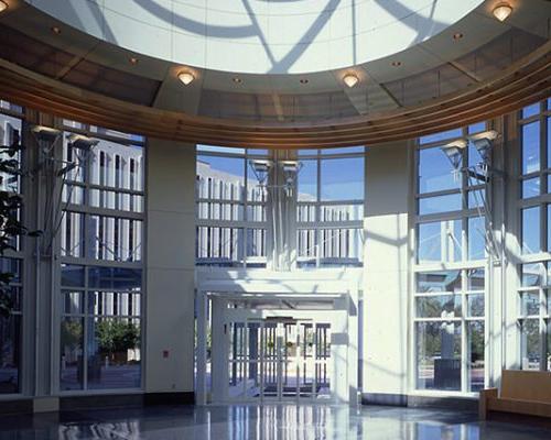 Interior photo of main entry. Glass dome and full height windows on the walls surround main doors.